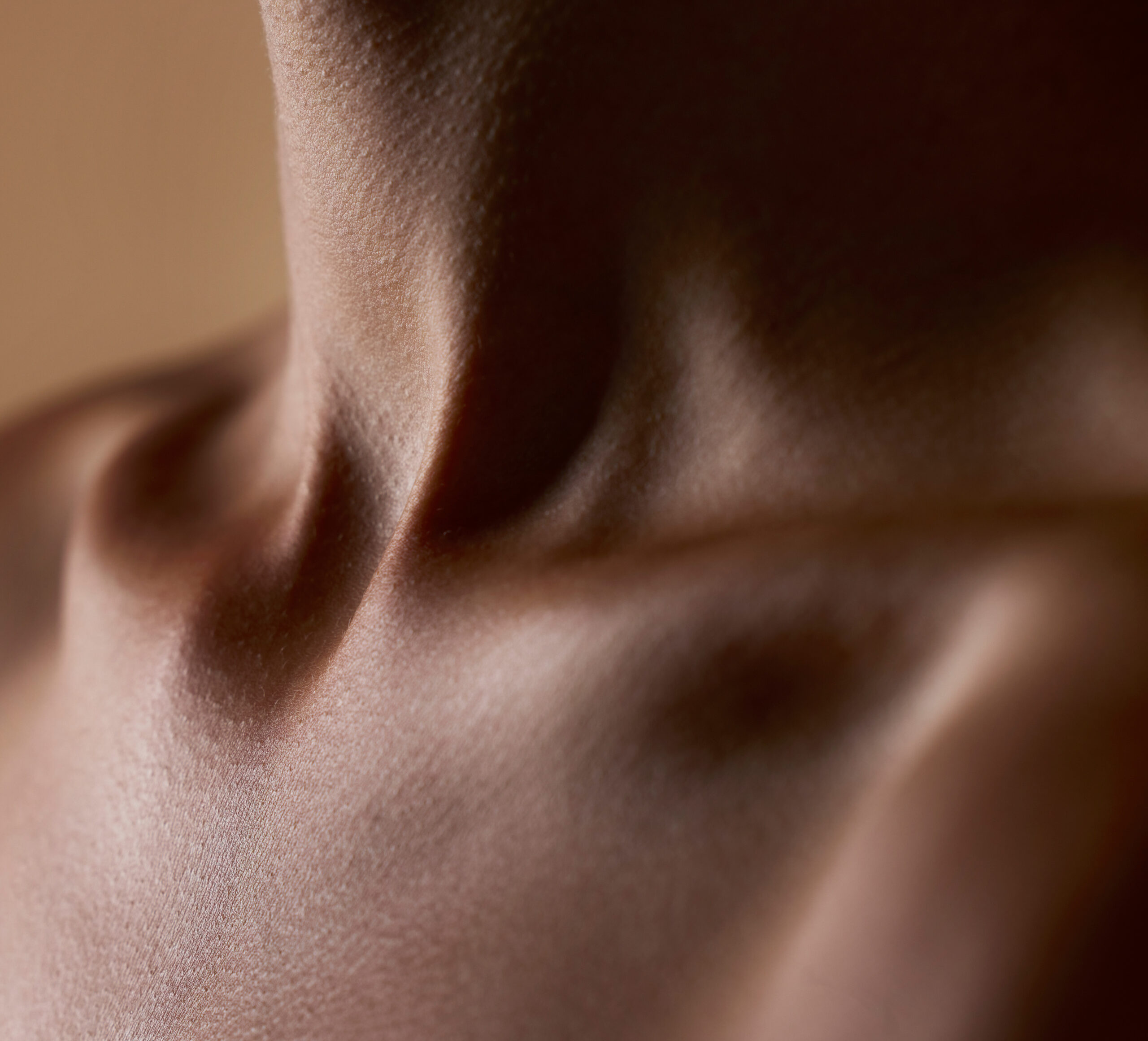 Close-up of a woman's neck and collarbone, soft lighting