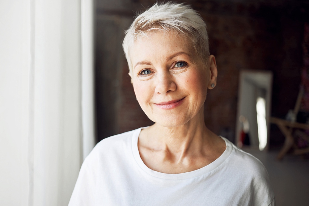 Age, beauty, wellbeing and health concept. Close up portrait of good looking beautiful mature female with gray pixie hair, blue eyes and wrinkles smiling happily at camera, being in good mood Facelift in Bucks County, PA and Hunterdon County, NJ