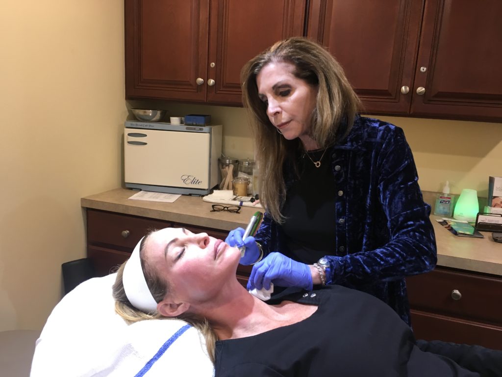 Provider using a handheld device during a MIRApeel treatment on a patient