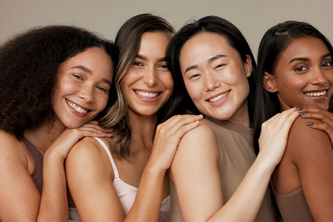 Four smiling women embracing in a group portrait
